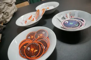 Bowls of various Astro stickers, some that look like mission badges.